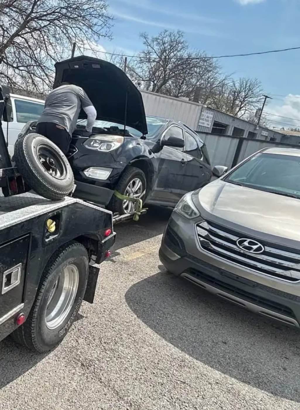 Trabajador revisando el motor de una camioneta antes de subirla a la grúa